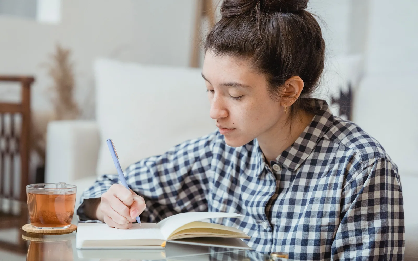 Une rédactrice écrit dans un carnet à son bureau